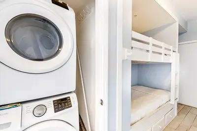 a laundry room with a washing machine and a bunk bed at Breathtaking gulf-front condo near Pier Park in Panama City Beach