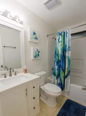 a bathroom with a toilet and a shower curtain at Stunning 4BD Jacuzzi - 4 Min To Beach Panama City in Panama City Beach
