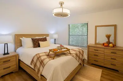 a bedroom with a bed with a table on it at Stunning 4BD Jacuzzi - 4 Min To Beach Panama City in Panama City Beach