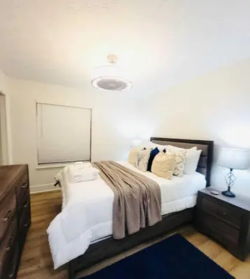 a bedroom with a large bed with white sheets and pillows at Stunning 4BD Jacuzzi - 4 Min To Beach Panama City in Panama City Beach