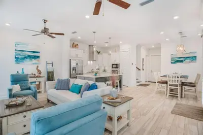 a living room with blue furniture and a kitchen at Feeling Tip Sea Golf Cart Bikes Prominence in Watersound Beach