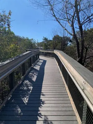 a pedestrian bridge over a trail in a park at Feeling Tip Sea Golf Cart Bikes Prominence in Watersound Beach