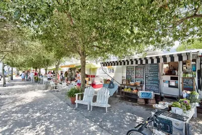 a group of tables and chairs in front of a store at Feeling Tip Sea Golf Cart Bikes Prominence in Watersound Beach