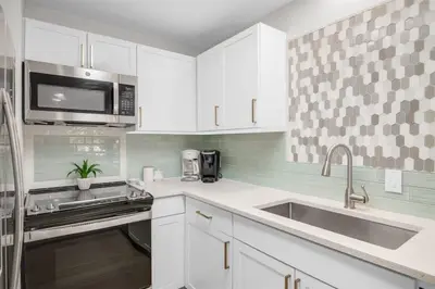 a white kitchen with a sink and a microwave at After Dune Delight Pool Tennis Walk To Beach in Seagrove Beach