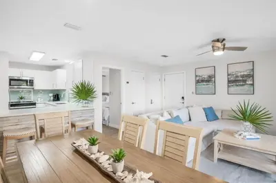 a living room and kitchen with a couch and a table at After Dune Delight Pool Tennis Walk To Beach in Seagrove Beach