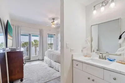 a bathroom with a sink and a bedroom with a bed at Salt Rim Located In Carillon Beach 4 Pools in Carillon Beach