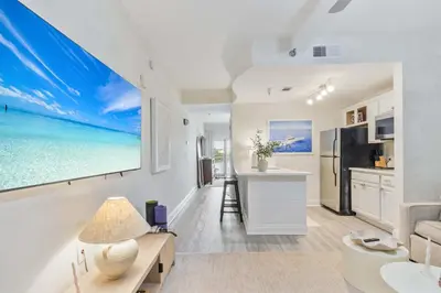 a kitchen and living room with a large painting on the wall at Salt Rim Located In Carillon Beach 4 Pools in Carillon Beach