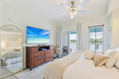a bedroom with a bed and a dresser with a mirror at Salt Rim Located In Carillon Beach 4 Pools in Carillon Beach
