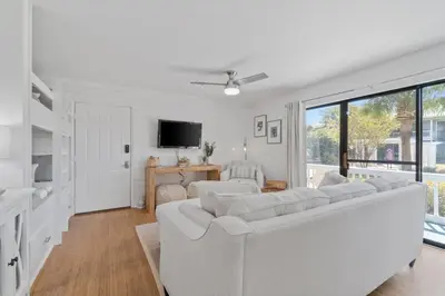 a white living room with a white couch and a tv at Sea Esta 30A Beautiful Condo Close To Beach in Seagrove Beach