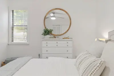 a white bedroom with a dresser and a mirror at Sea Esta 30A Beautiful Condo Close To Beach in Seagrove Beach