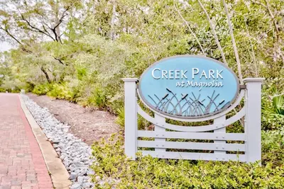 a sign at the entrance to a green park at 30A Caspian Blue Carriage in Seacrest