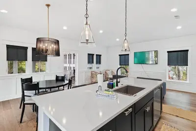 a kitchen with a white counter and a dining room at 30A Caspian Blue Carriage in Seacrest