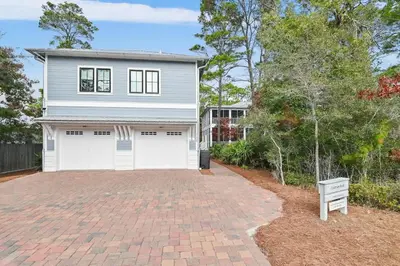 a house with two garage doors on a brick driveway at 30A Caspian Blue Carriage in Seacrest