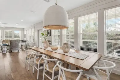 a dining room with a table and chairs and windows at Beach Retreat Gulf View Private Beach in Seacrest