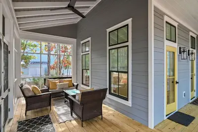 a screened in porch with a table and chairs at 30A Caspian Blue Cottage in Seacrest