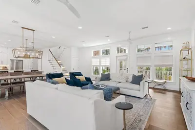 a living room with a white couch and a kitchen at 30A Caspian Blue Cottage in Seacrest