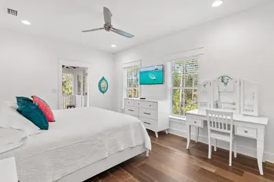 a white bedroom with a bed and a desk at 30A Caspian Blue Cottage in Seacrest