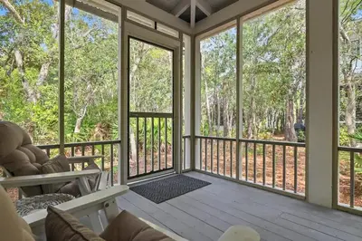 a screened in porch with a view of trees at Driftwood Place Renovations Underway Bikes in Seacrest