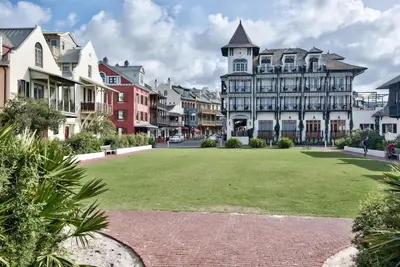 a large lawn in front of a large building at Driftwood Place Renovations Underway Bikes in Seacrest