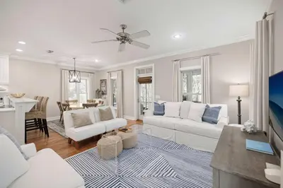 a living room with white furniture and a dining room at Driftwood Place Renovations Underway Bikes in Seacrest