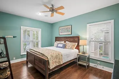a bedroom with blue walls and a bed with a ceiling fan at Mississippi Magnolia 3 BR 3BA Walk To Beach in Seacrest