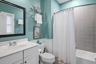 a bathroom with a white toilet and a sink at Mississippi Magnolia 3 BR 3BA Walk To Beach in Seacrest