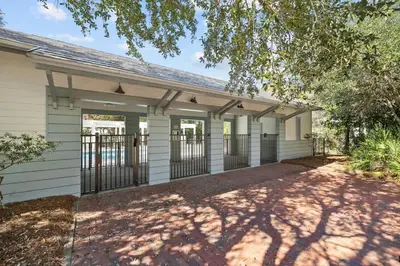 a white house with a fence and a driveway at Mississippi Magnolia 3 BR 3BA Walk To Beach in Seacrest