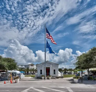 an american flag on a pole in front of a building at Mississippi Magnolia 3 BR 3BA Walk To Beach in Seacrest