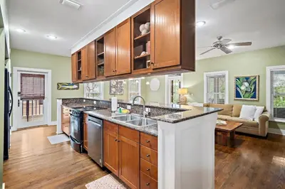 a kitchen with wooden cabinets and a large island at Mississippi Magnolia 3 BR 3BA Walk To Beach in Seacrest