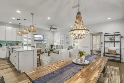 a kitchen and living room with a table and a dining room at Southern Tides 4BR 4 5BA Sleeps 14 Golf Cart in Seacrest