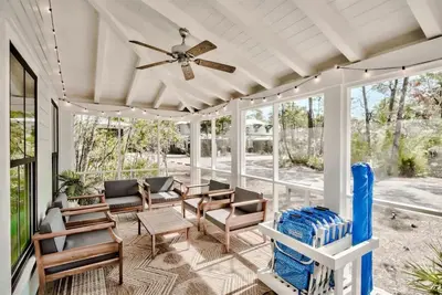 a screened porch with a ceiling fan and chairs at Southern Tides 4BR 4 5BA Sleeps 14 Golf Cart in Seacrest