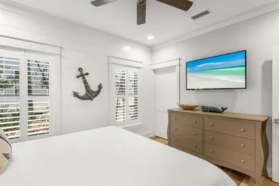 a bedroom with a bed and a flat screen tv at Southern Tides 4BR 4 5BA Sleeps 14 Golf Cart in Seacrest