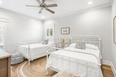 a white bedroom with two beds and a ceiling fan at Southern Tides 4BR 4 5BA Sleeps 14 Golf Cart in Seacrest