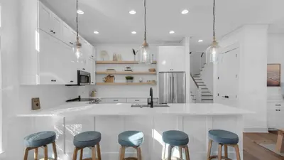 a kitchen with white cabinets and blue stools at Vitamin Sea 4BR 4 5BA Golf Cart Pet Friendly in Seacrest