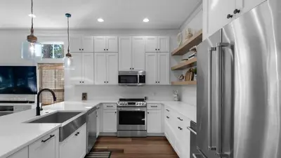 a kitchen with white cabinets and a stainless steel refrigerator at Vitamin Sea 4BR 4 5BA Golf Cart Pet Friendly in Seacrest