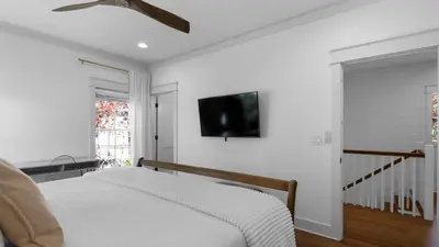 a bedroom with a bed and a tv on the wall at Vitamin Sea 4BR 4 5BA Golf Cart Pet Friendly in Seacrest