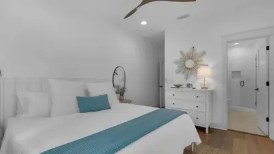 a white bedroom with a bed and a dresser and a mirror at Vitamin Sea 4BR 4 5BA Golf Cart Pet Friendly in Seacrest