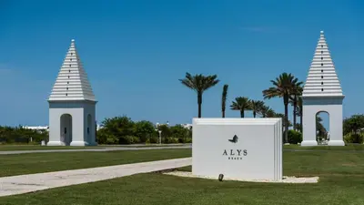 a sign in the grass with two towers in the background at Vitamin Sea 4BR 4 5BA Golf Cart Pet Friendly in Seacrest