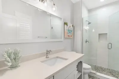 a white bathroom with a sink and a shower at The Crab House Golf Cart Bikes in Seacrest