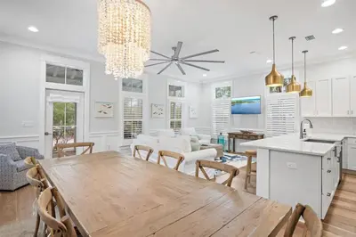 a kitchen and dining room with a wooden table and chairs at The Crab House Golf Cart Bikes in Seacrest