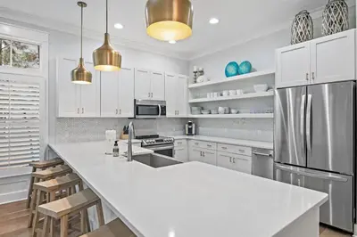 a kitchen with white cabinets and a large white counter top at The Crab House Golf Cart Bikes in Seacrest