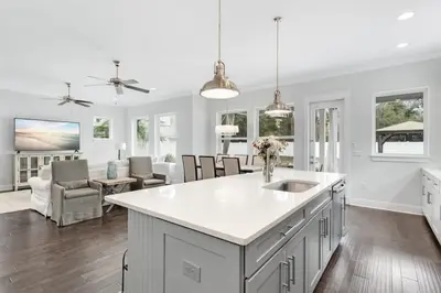 a white kitchen with a sink and a living room at Sea Change At Eastern Lake Private Pool in Watersound Beach