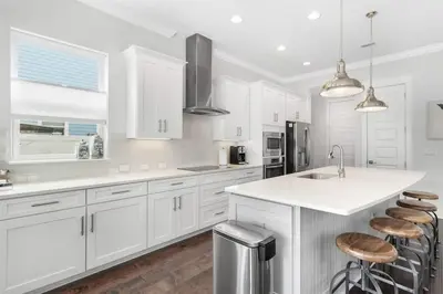 a white kitchen with white cabinets and a counter at Sea Change At Eastern Lake Private Pool in Watersound Beach