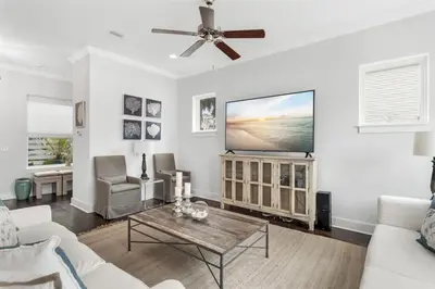 a living room with a ceiling fan and a tv at Sea Change At Eastern Lake Private Pool in Watersound Beach