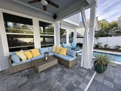 a screened in porch with a couch and a pool at Sea Change At Eastern Lake Private Pool in Watersound Beach