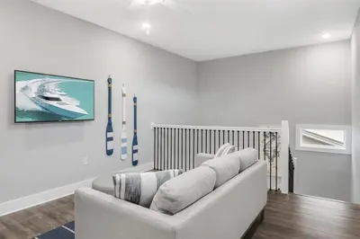 a white living room with a white couch and a wall at A Wave From It All Bikes Lake Grill in Inlet Beach