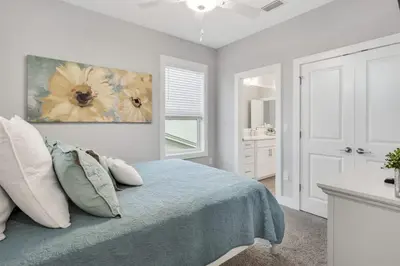 a bedroom with a bed with a flower painting on the wall at A Wave From It All Bikes Lake Grill in Inlet Beach