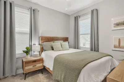 a white bedroom with a large bed and windows at A Wave From It All Bikes Lake Grill in Inlet Beach