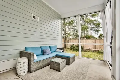 a patio with a blue couch on a porch at A Wave From It All Bikes Lake Grill in Inlet Beach