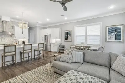 a living room with a couch and a kitchen at A Wave From It All Bikes Lake Grill in Inlet Beach